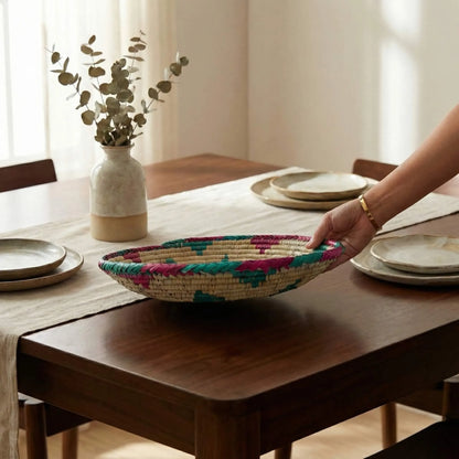 Artisanal Mazari palm plate being served, highlighting the lightweight and durable hand-coiled structure.