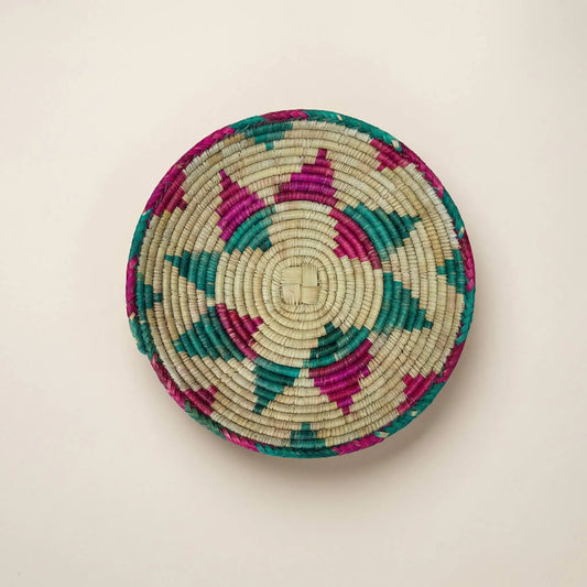 Detailed overhead view of the SHKOR signature plate showing the intricate sunburst weave and natural sage-tan fibers.