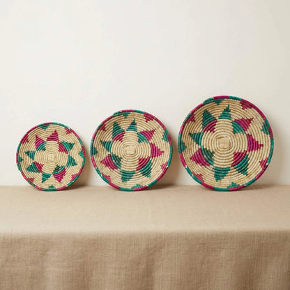 A collection of SHKOR Signature plates in small, medium, and large sizes showing teal and fuchsia geometric patterns.